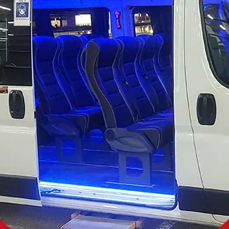 Interior de un minibús de Transfer Chile con asientos y luces LED azules