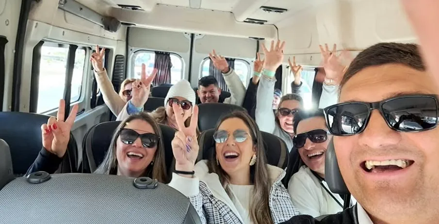 Pasajeros sonriendo a bordo de una van de Transfer Chile